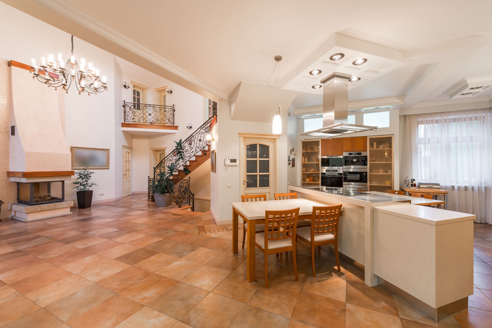 An open plan space with a sofa zone, a dining table and a kitchen sharing one room