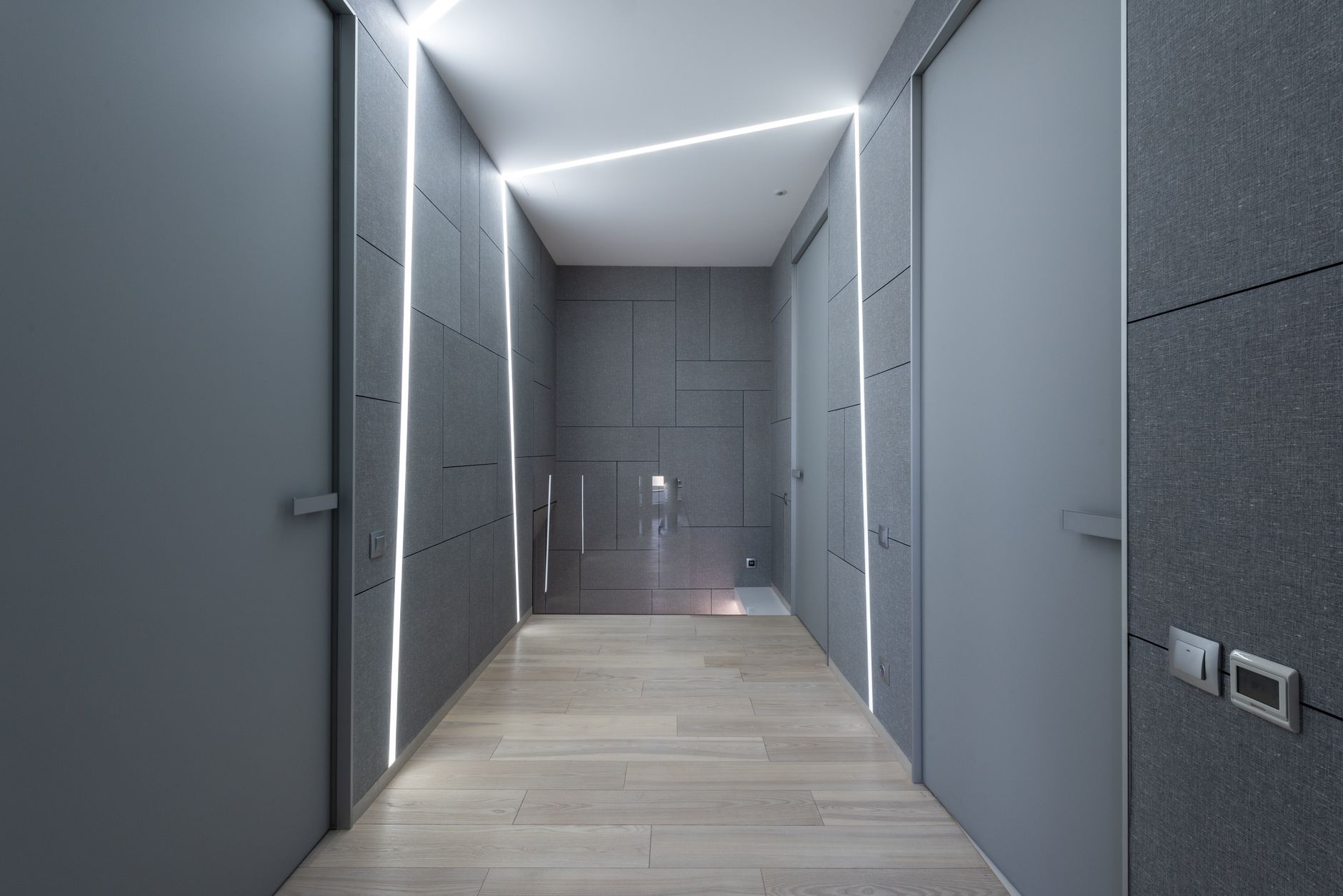 A long narrow hallway with doors along both sides